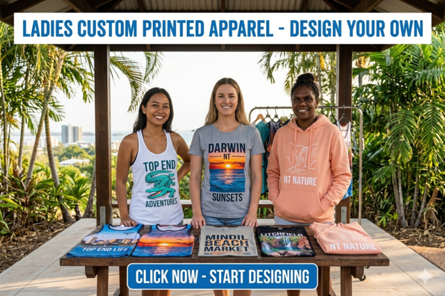 A selection of ladies' custom-printed tank tops, t-shirts, and hoodies featuring Darwin-inspired designs like crocodiles and Litchfield National Park. The apparel is displayed against a backdrop of the Darwin city skyline and coastline. The image includes the text 'LADIES CUSTOM PRINTED APPAREL