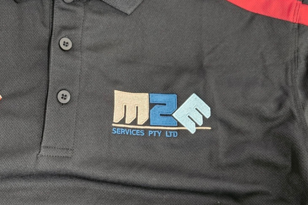 Business logo embroidered on left chest of black polo shirts